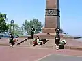 Male and female cadets bowing their heads in respect while guarding the monument