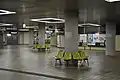 The station concourse in June 2015. The yellow wall is a semi-permanent barrier that blocks off the former lobby and stairs to the unused platform.