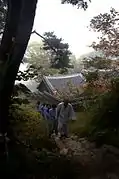 Monk and Templestay guests walk up a wooded path in the temple (2008)