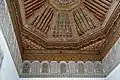 Details of the decorated ceiling, including sculpted and painted stucco just below the wooden ceiling