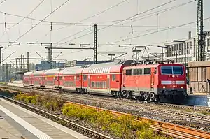 Five red double-decker carriages and a red locomotive