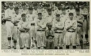 Seventeen baseball players wearing light uniforms with dark vertical pinstripes standing with their arms crossed.