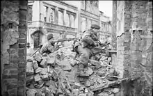 two men in a rubble strewn street