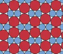 In work dedicated to Fejes Tóth, this compact binary circle packing was shown to be the densest possible planar packing of discs with this size ratio.