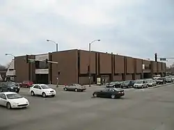 Brown, brutalist corner building viewed at an angle