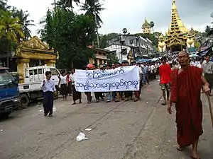 Image 20Protesters in Yangon with a banner that reads non-violence: national movement in Burmese, in the background is Shwedagon Pagoda. (from History of Myanmar)