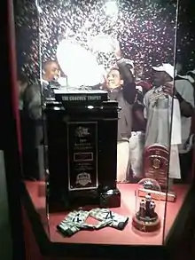 Coaches' Trophy and championship rings in a displaycase.