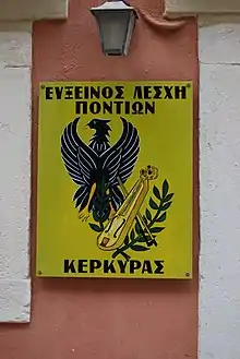 Painting of eagle and kemenche on yellow background, with Greek writing