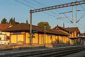 Two-story building with gabled roof and adjoining single-story shed