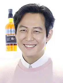 Lee smiling dressed in pink shirt