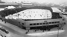 Aerial image of a stadium with a snow-covered ground and packed stands