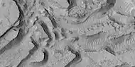 Enlarged view of a group of mesas, as seen by HiRISE under HiWish program One surface is forming square shapes.