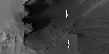 Boulders and their tracks from rolling down a slope, as seen by HiRISE under HiWish program Arrows show two boulders at the end of their tracks.