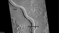 Context for next image of layers along Hrad Vallis, as seen by CTX.  Photo labeled with layers, streamlined forms, and arrow indicating direction water flowed.