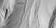 Close view of gully channel, as seen by HiRISE under HiWish program  Arrow shows small channel within larger channel.  Small channel is quite curved in this image.