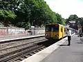 A Merseyrail Class 507 waits at the station.