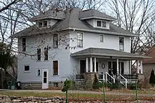 Image 1A wood-frame American Foursquare house in Minnesota with dormer windows on each side and a large front porch