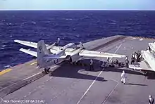 Colour photograph of aircraft on the flight deck of an aircraft carrier