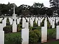 Commonweath war grave headstones and the Cross of Sacrifice, looking south-east (2021).