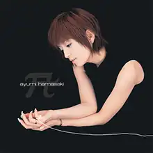 An image of Ayumi Hamasaki sitting down in a black backdrop, merging with her black dress. She features dark-red hair in a crop hairstyle, with a long piece of digitally-altered string on her hand with the song and artist title on the left.