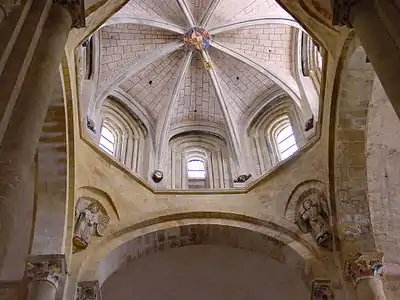 The lantern of the Abbey Church of Sainte-Foy in Conques (11th–12th century) The squinches joining  the supporting arches of the lantern are  decorated with sculpture of the Apostles. The base is Romanesque,  while the lantern itself is later Gothic.