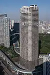 Aerial view of a brown and beige, rectangular, window-dotted high-rise