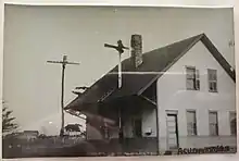 A black-and-white postcard of a two-story wooden railway station