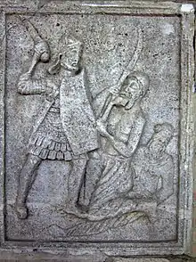 Metope XX: Legionary with manica laminata and body defences of 'pteruges' and a corselet of scale, armed with sword, and a Dacian falxman; A Germanic warrior (Bastarnae?) sporting a Suebian knot lies injured on the ground