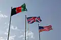 Afghan, British and US flags on poles during a ceremony in Helmand Province (2010)