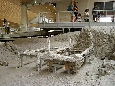 Plaster moulds of bedframes from the 1500s BC Akrotiri settlement, looking like modern charpais. Such frames are light; one has been stacked upside-down on another. Note turned wood leg, far right.