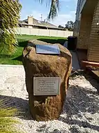 Rock monument and its nearby flagpole honouring mosque founders