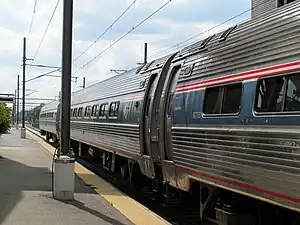 Corrugated silver tubular rail cars with red, white, and blue striping