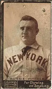 A baseball player is seen from his chest up, facing slightly left of the camera.