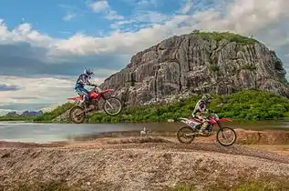 Bike riders beside monolith