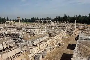 The strewn stone remains of an ancient city, including arcades