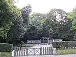 Torii gate and concrete fence among trees.