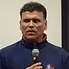 Headshot of Anthony Munoz holding a microphone