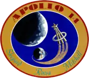 The circular patch depicts the Earth and the Moon. An astronaut lapel pin leaves a comet trail from the liftoff point on Earth. Around it is the logo "Apollo 14 – Shepard Roosa Mitchell"