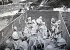 Inside view of British soldiers firing through gun slits from within an armoured train coach