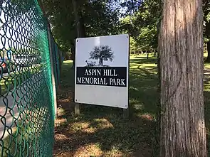 A cemetery sign adjacent to a perimeter fence