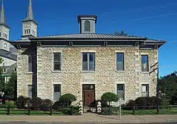 Two-story stone building with a central cupola