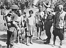 Image 18Australian soldiers and local civilians on Labuan Island. The soldier on the left is armed with an Australian-designed Owen gun. (from Military history of Australia during World War II)