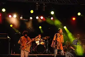 Musicians on stage with several spotlights above them