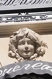 Beaux Arts mascaron with lavander in its hair, above a window of the parfumery of Jacques and Pierre Guerlain