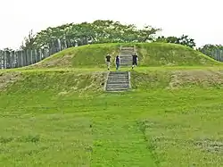 Image 54The largest platform mound at Aztalan, with modern reconstructions of steps and stockade (from History of Wisconsin)