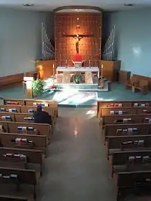 An aspiring seminarian on a vocational discernment retreat in solitary afternoon prayer before the altar in the chapel