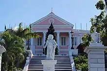 A building featuring a pediment and portico with a statue in front