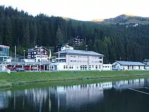 Three-story building with hip roof next to a lake