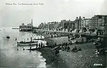 Piers supporting bandstand visible above beach, 1920s