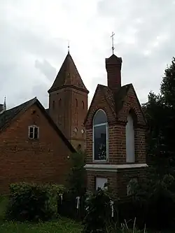 Old wayside shrine with the Saint Lawrence church in the background